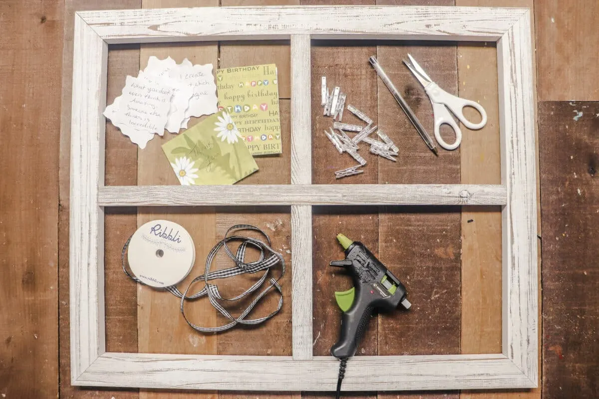 A wooden frame with scissors, glue, and other supplies.