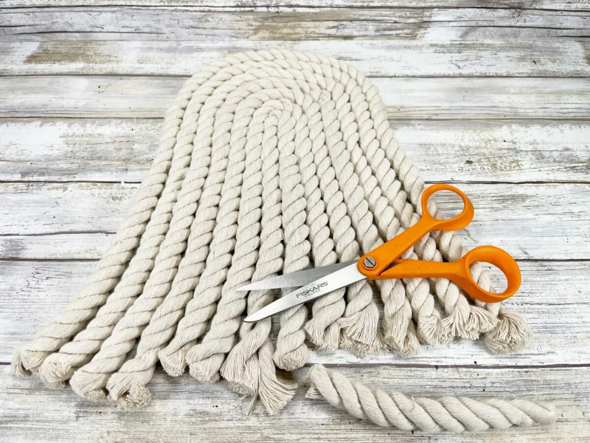 A pair of scissors and a rope on a wooden table.