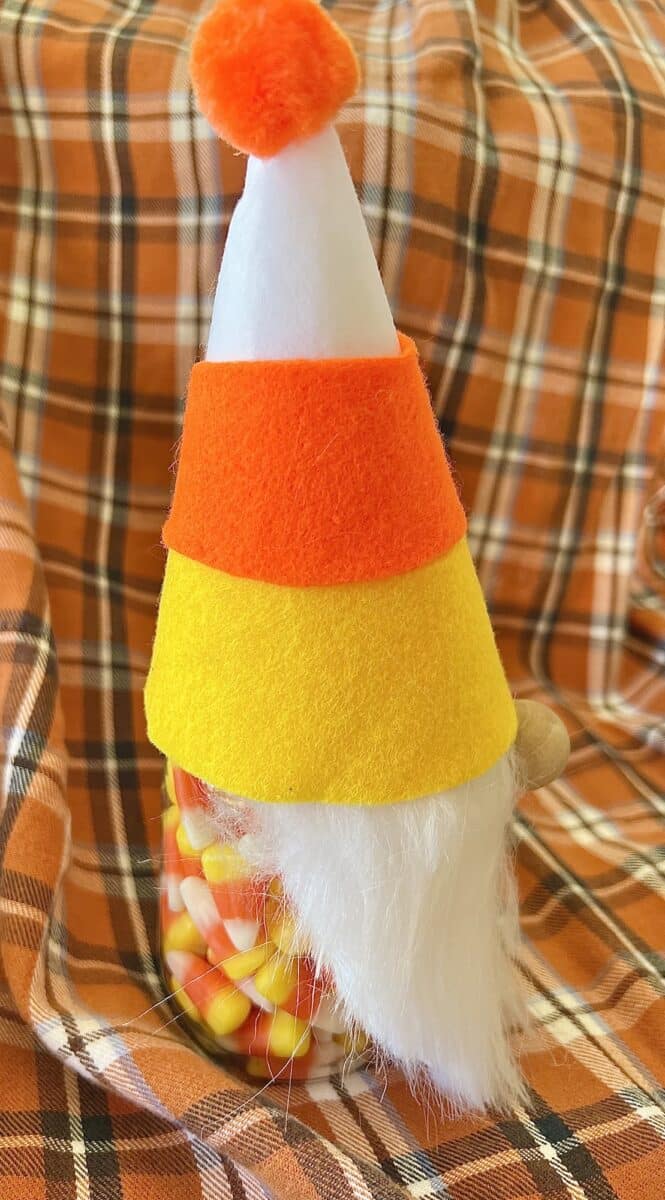A candy corn gnome on a tablecloth.