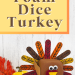 cute foam dice turkey standing in front of white wood background with faux pumpkin