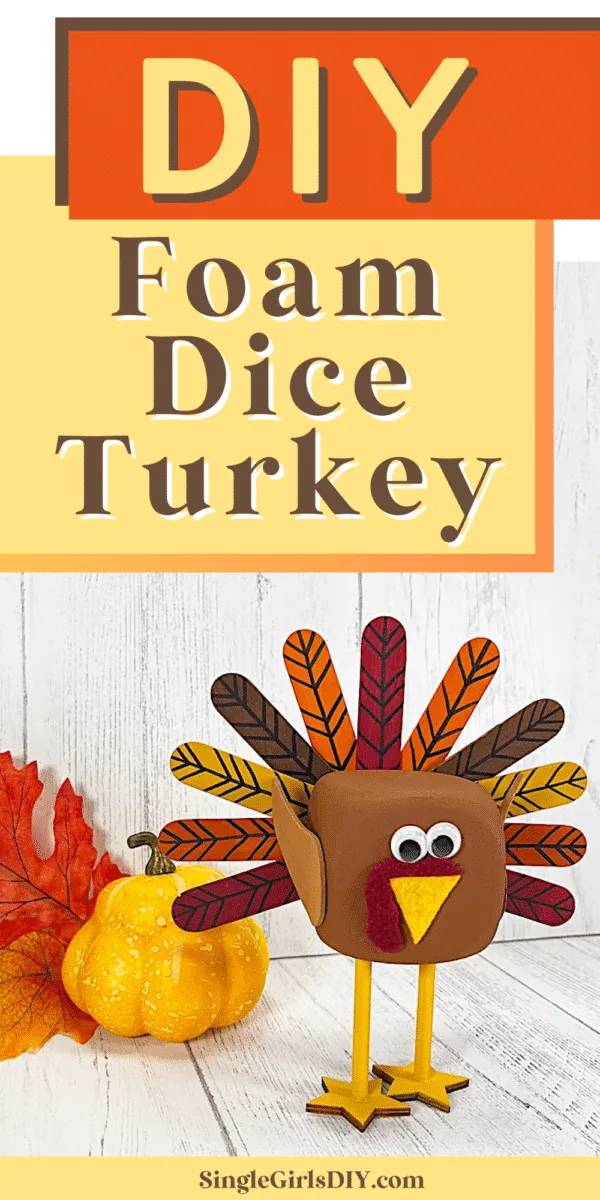 cute foam dice turkey standing in front of white wood background with faux pumpkin