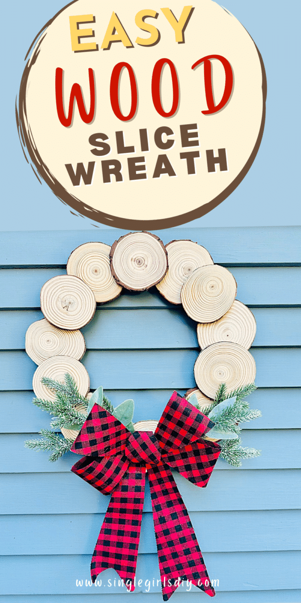 diy wood slice wreath with black and red checkered bow on blue wood background