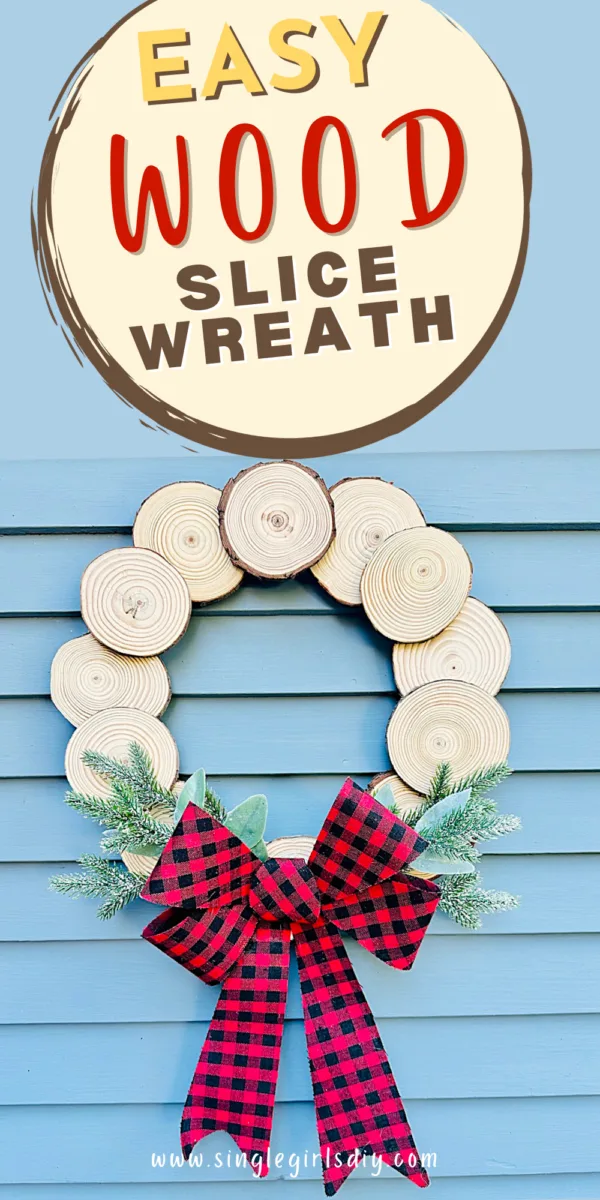 diy wood slice wreath with black and red checkered bow on blue wood background