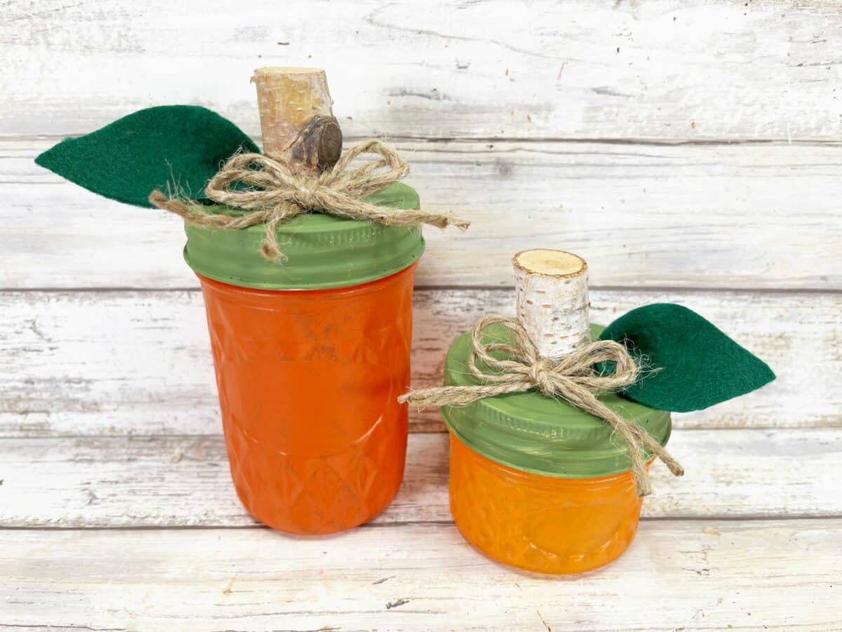 Two mason jars with leaves on them.