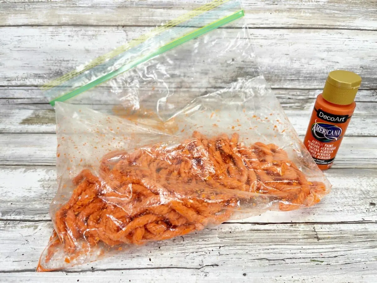 A bag of orange worms and a bottle of glue.