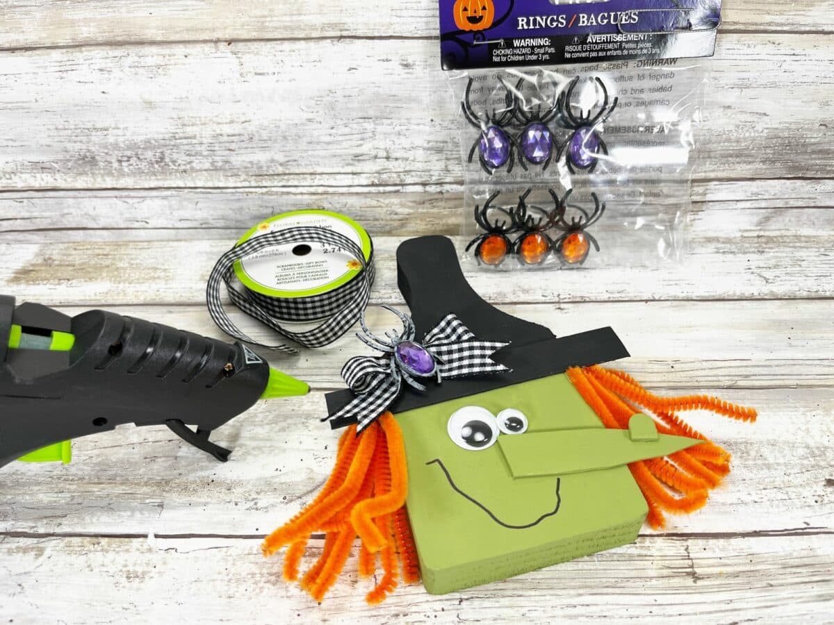 A halloween witch craft kit with a glue gun and other supplies.