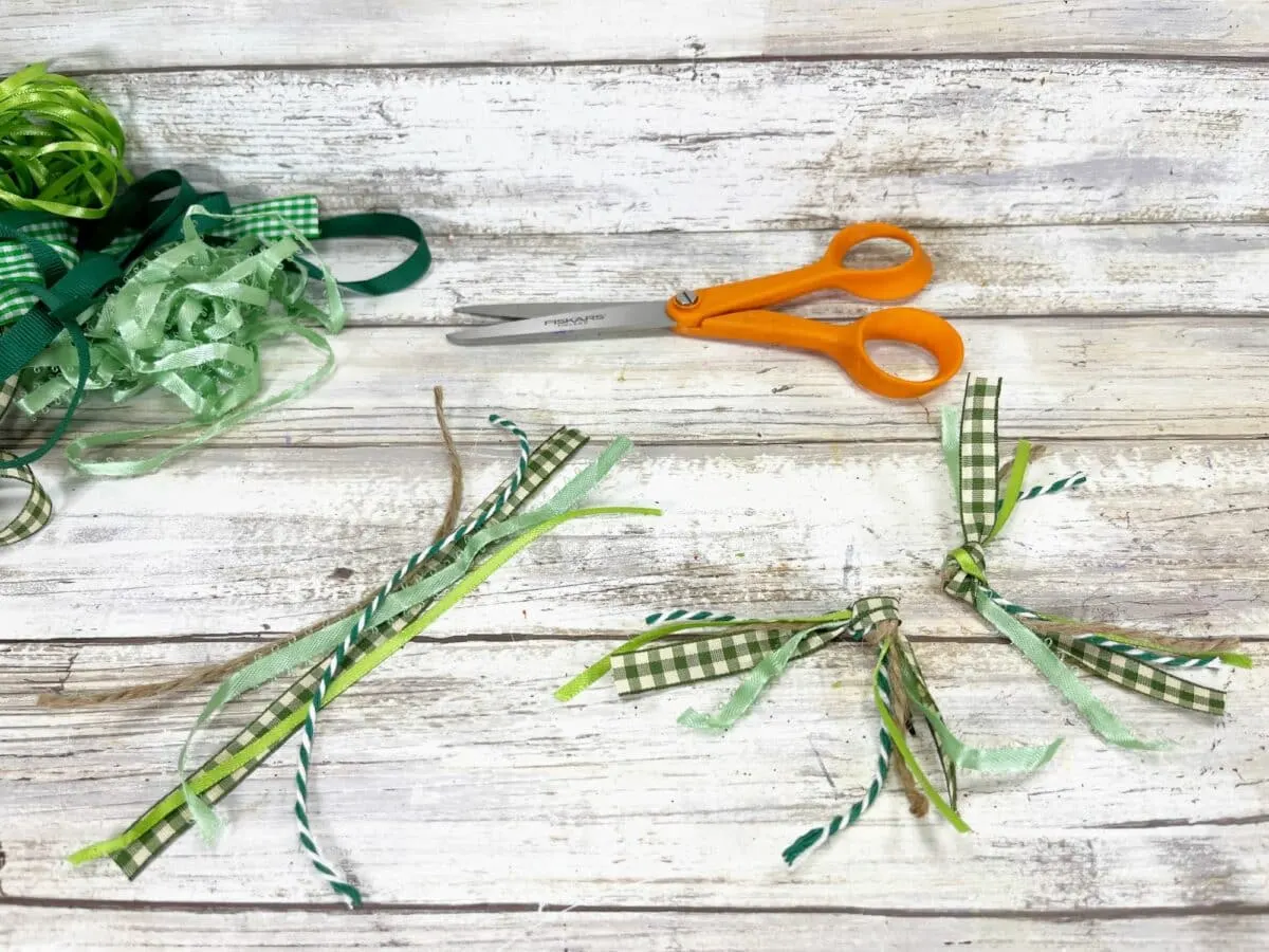 St patrick's day craft with green ribbon and scissors.