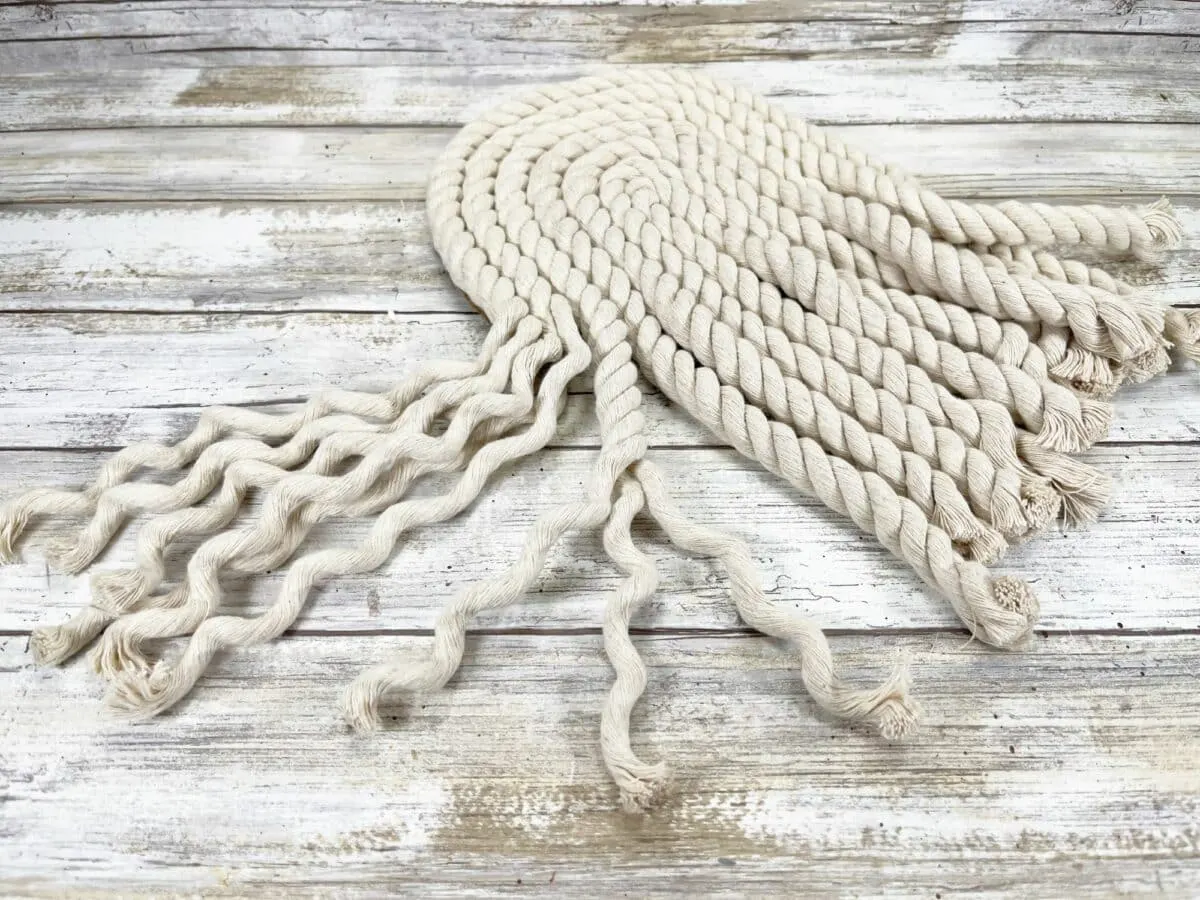 A white rope hanging on a wooden table.