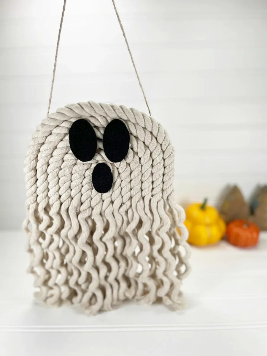 A white ghost hanging from a string on a table.