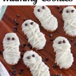 Mummy cookies with white icing and chocolate chip eyes rest on a wooden surface. Text overlay reads "3-Ingredient Mummy Cookies" and "SingleGirlsDIY.com".