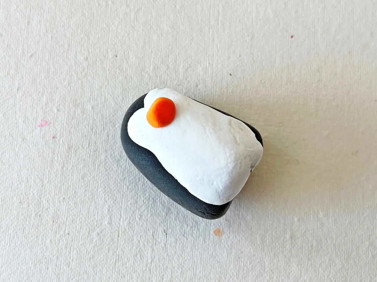 A black and white penguin on a white surface.