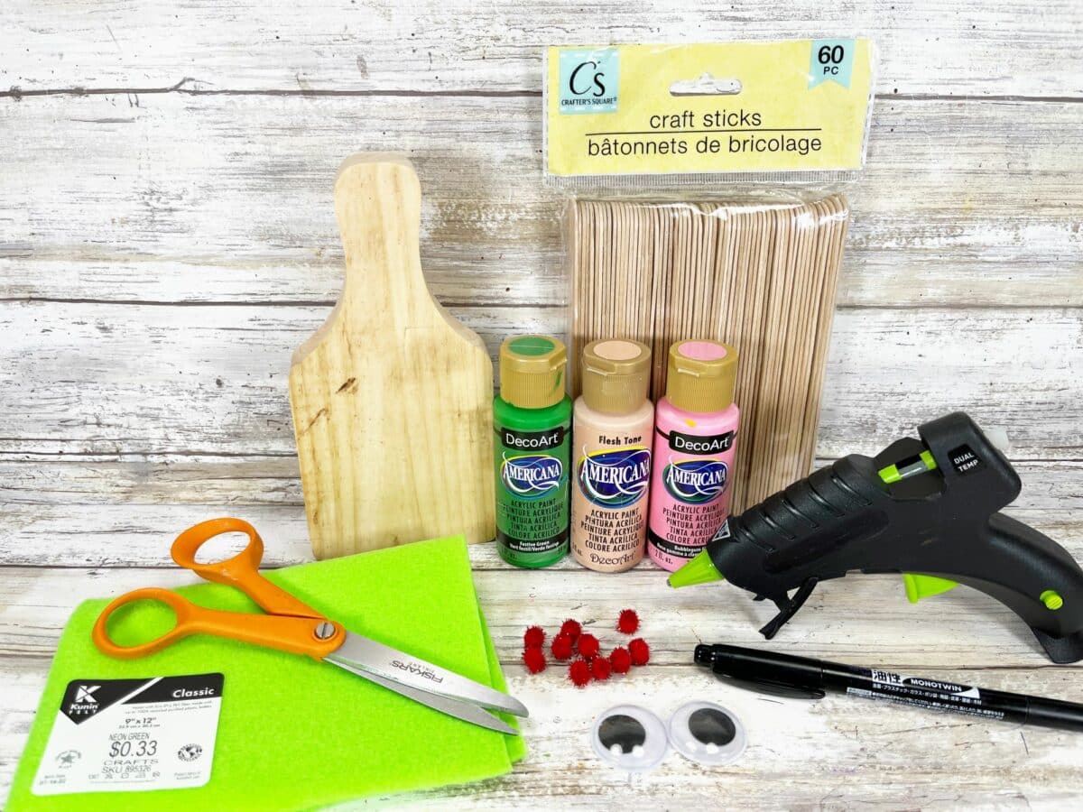 A craft kit with scissors, glue, and a wooden cutting board.