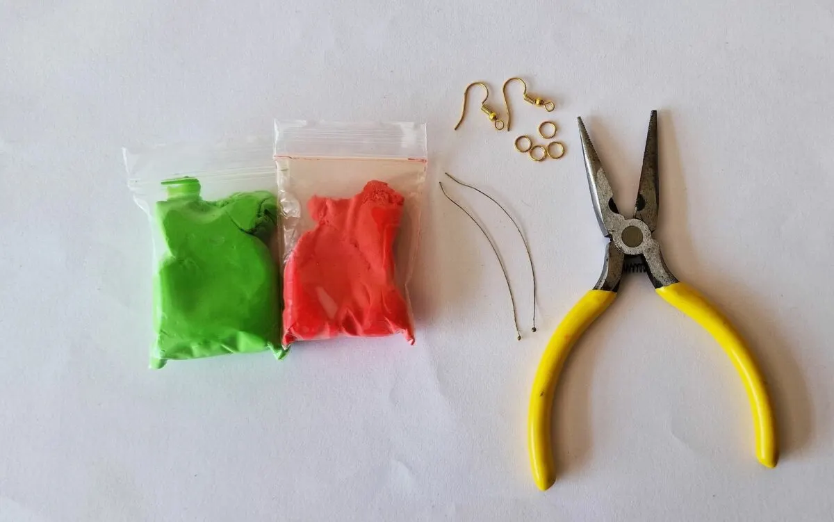 A pair of scissors, pliers, and a bag of colored beads.