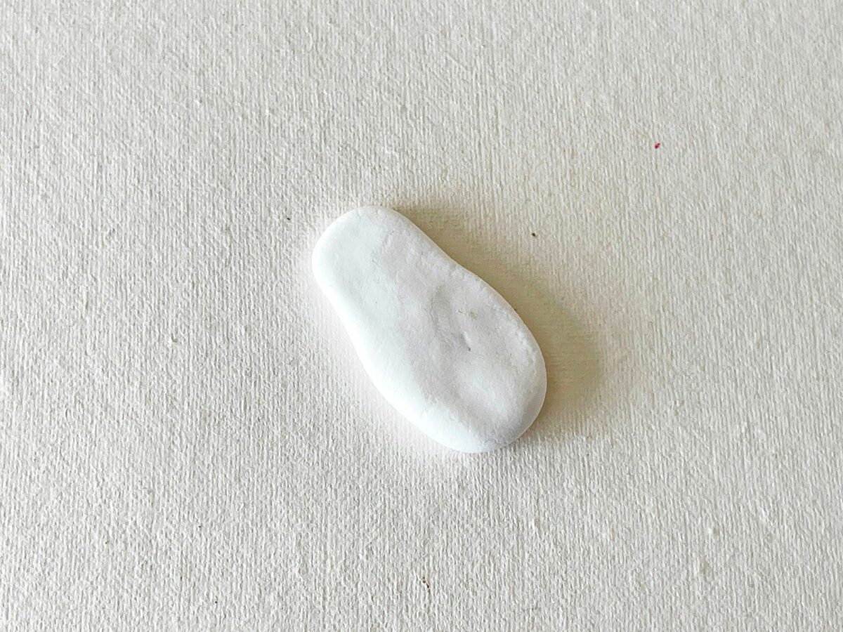 A small piece of white paint on a white surface.