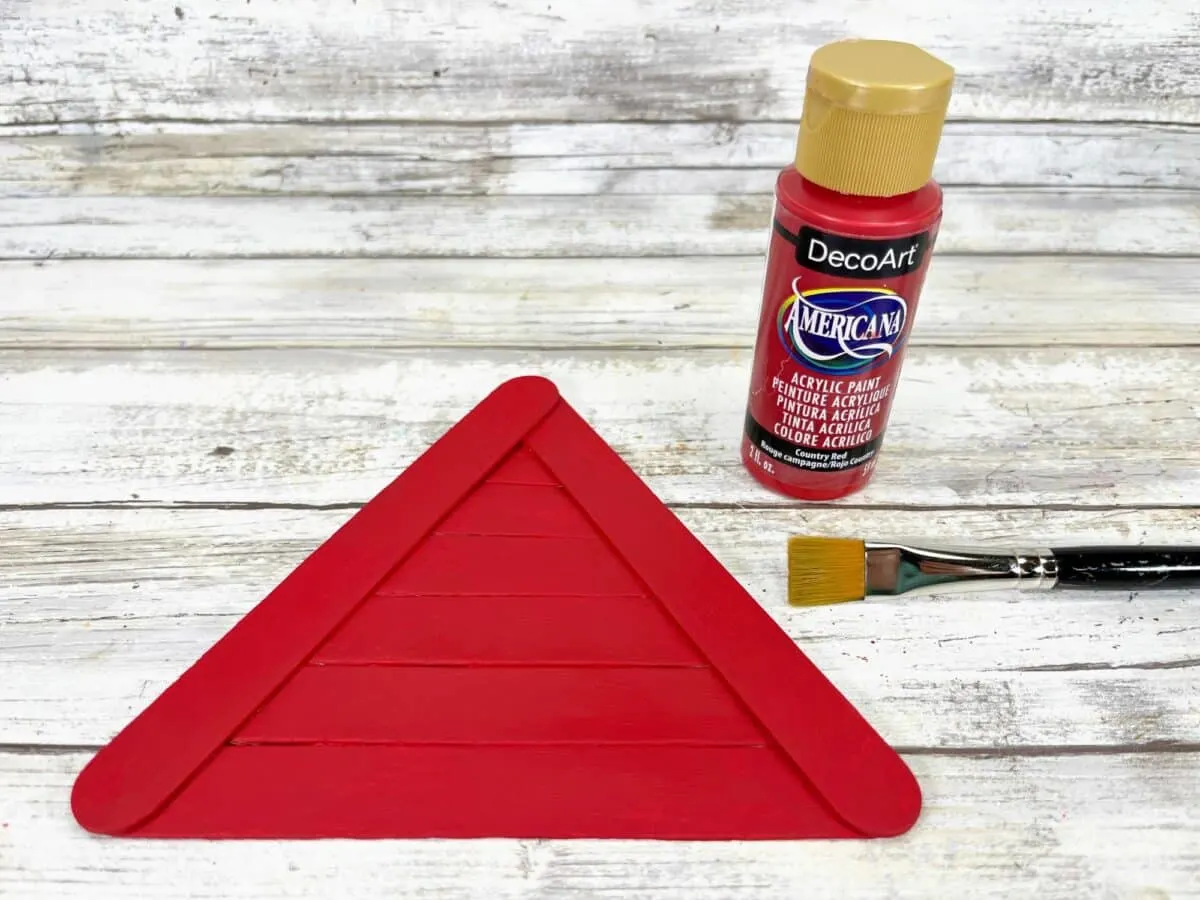 A red triangle with paint and a brush next to it.