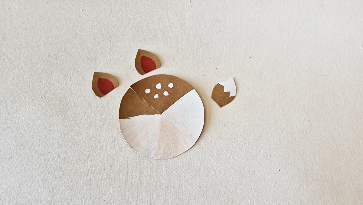 A paper cut out of a reindeer on a white surface.