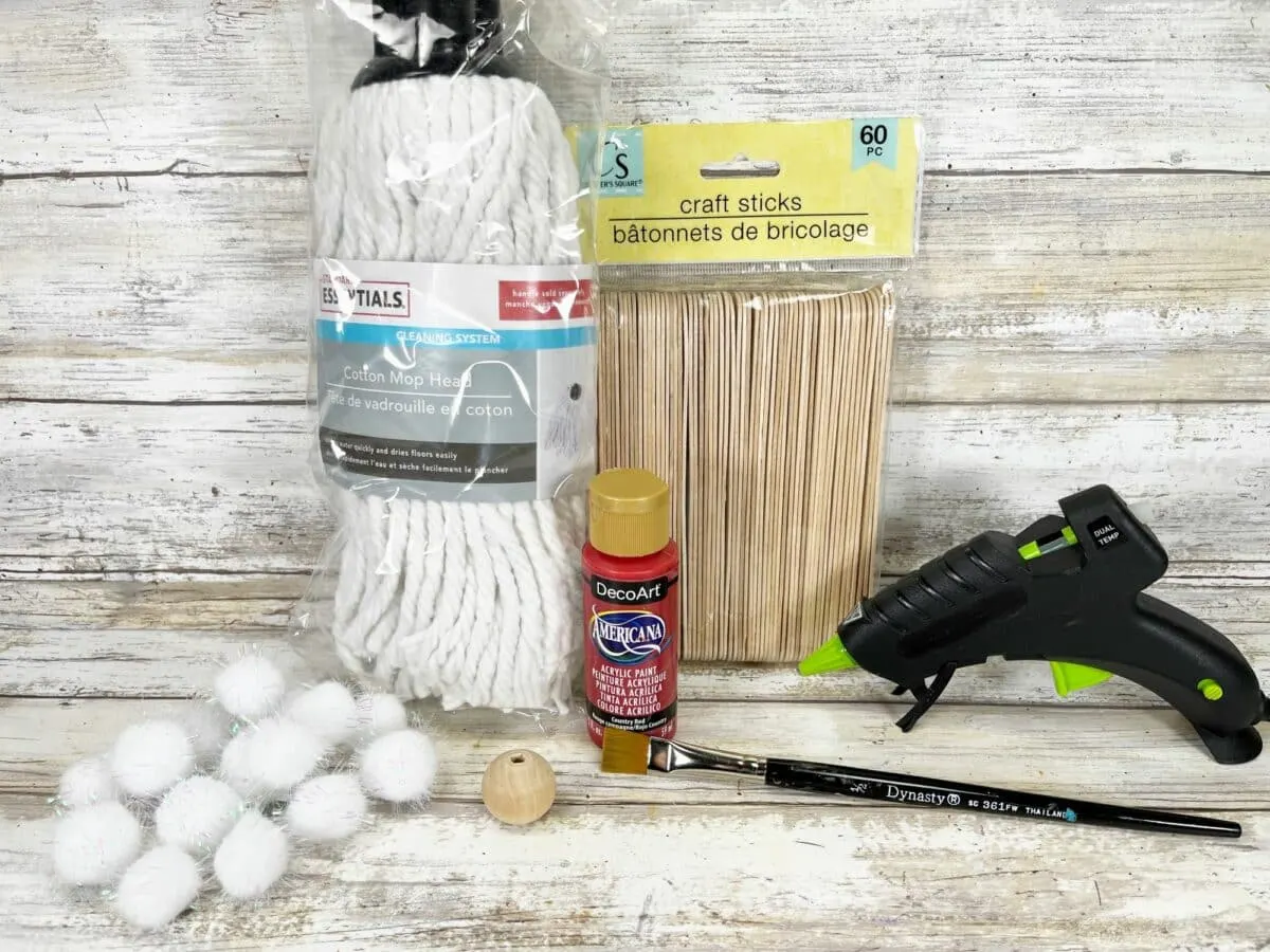 A craft kit with a glue gun, glue sticks, and cotton balls.