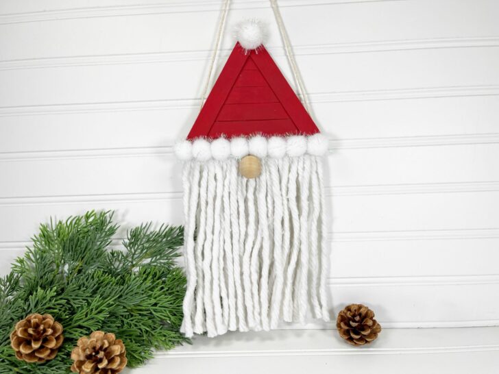 A santa hat hanging on a white wall.
