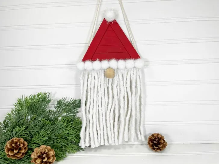A santa hat hanging on a white wall.