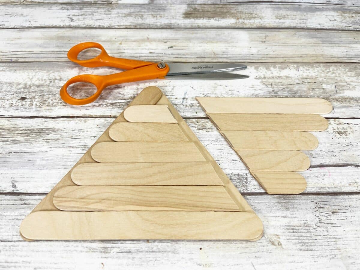 Popsicle sticks and scissors on a wooden table.