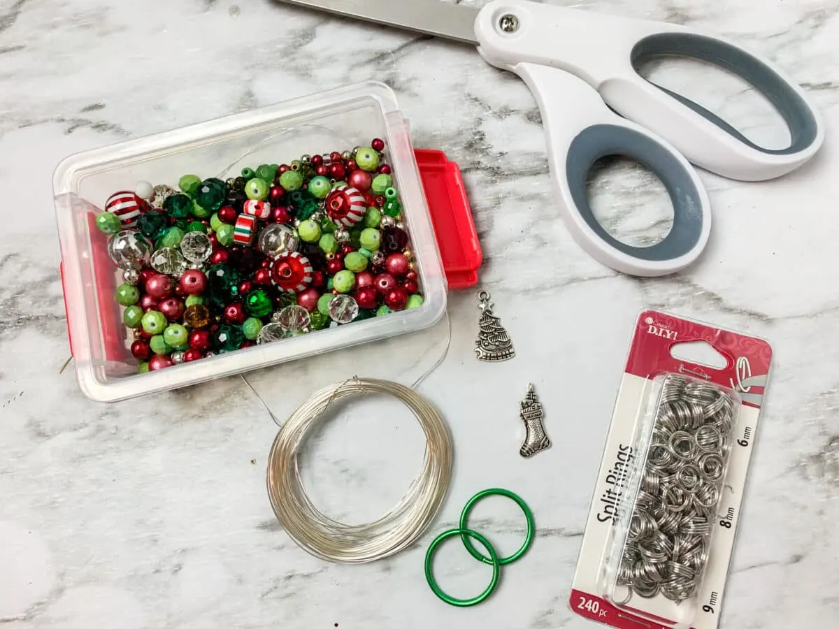 Christmas ornaments and scissors on a marble table.