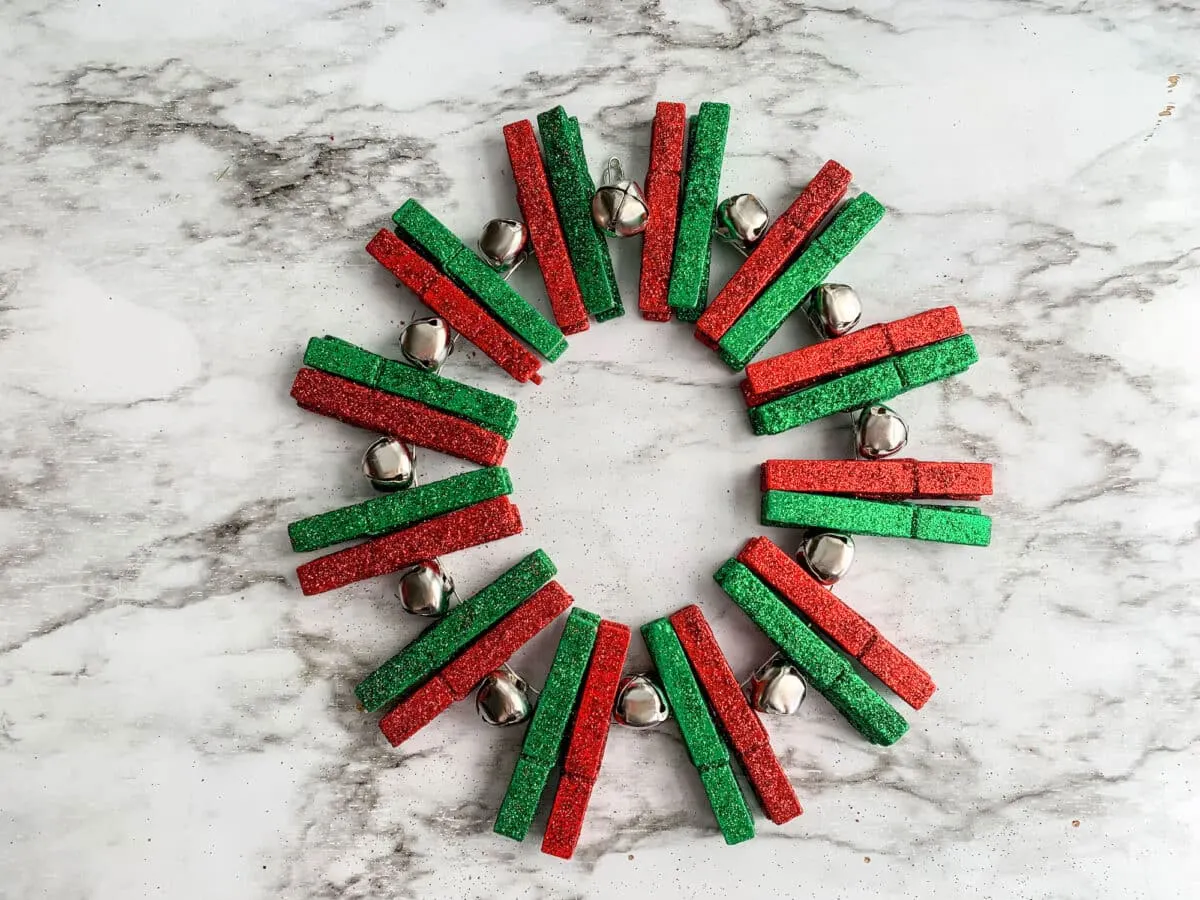 An advent wreath made of red and green clothes pegs.