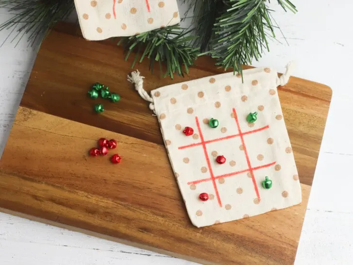 Two Christmas tic tac toe bags on a cutting board.