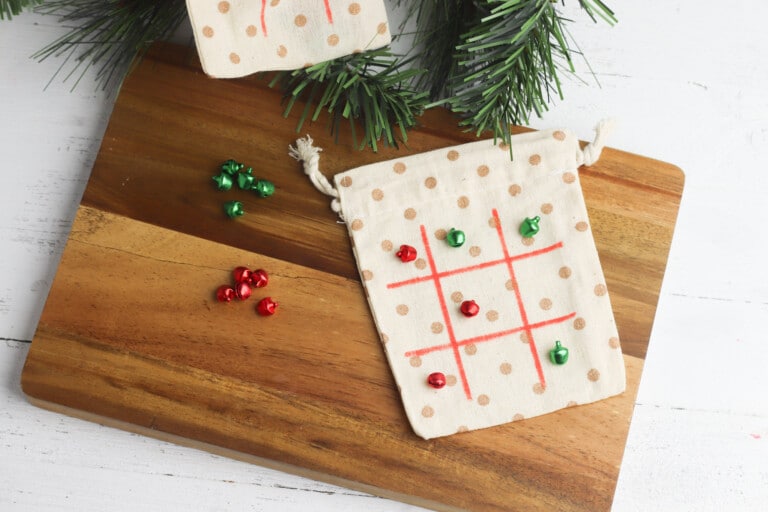 Two Christmas tic tac toe bags on a cutting board.