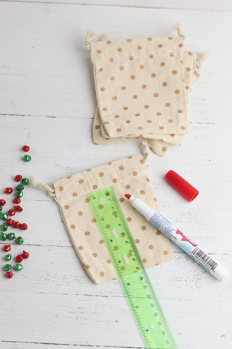 Polka dot gift bags with pom poms and a ruler.