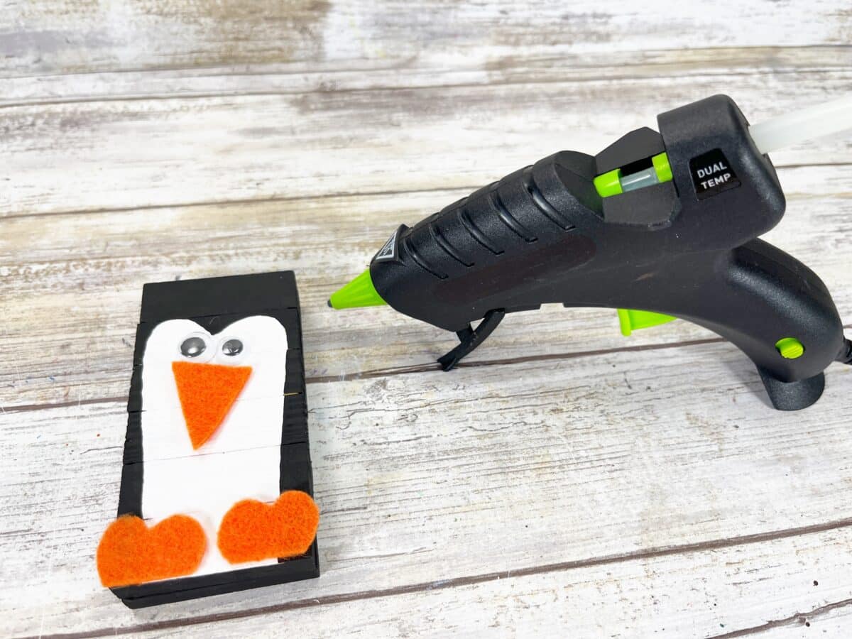 A penguin craft with a glue gun next to it.