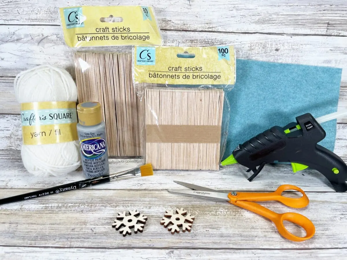 Snowflake craft kit with scissors, glue and yarn.