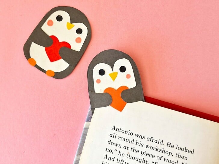 Two penguin bookmarks on a pink background.