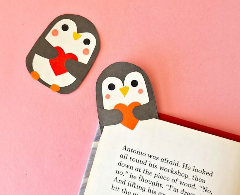 Two penguin bookmarks on a pink background.