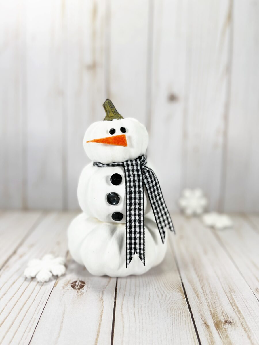 A snowman sitting on top of a wooden table.