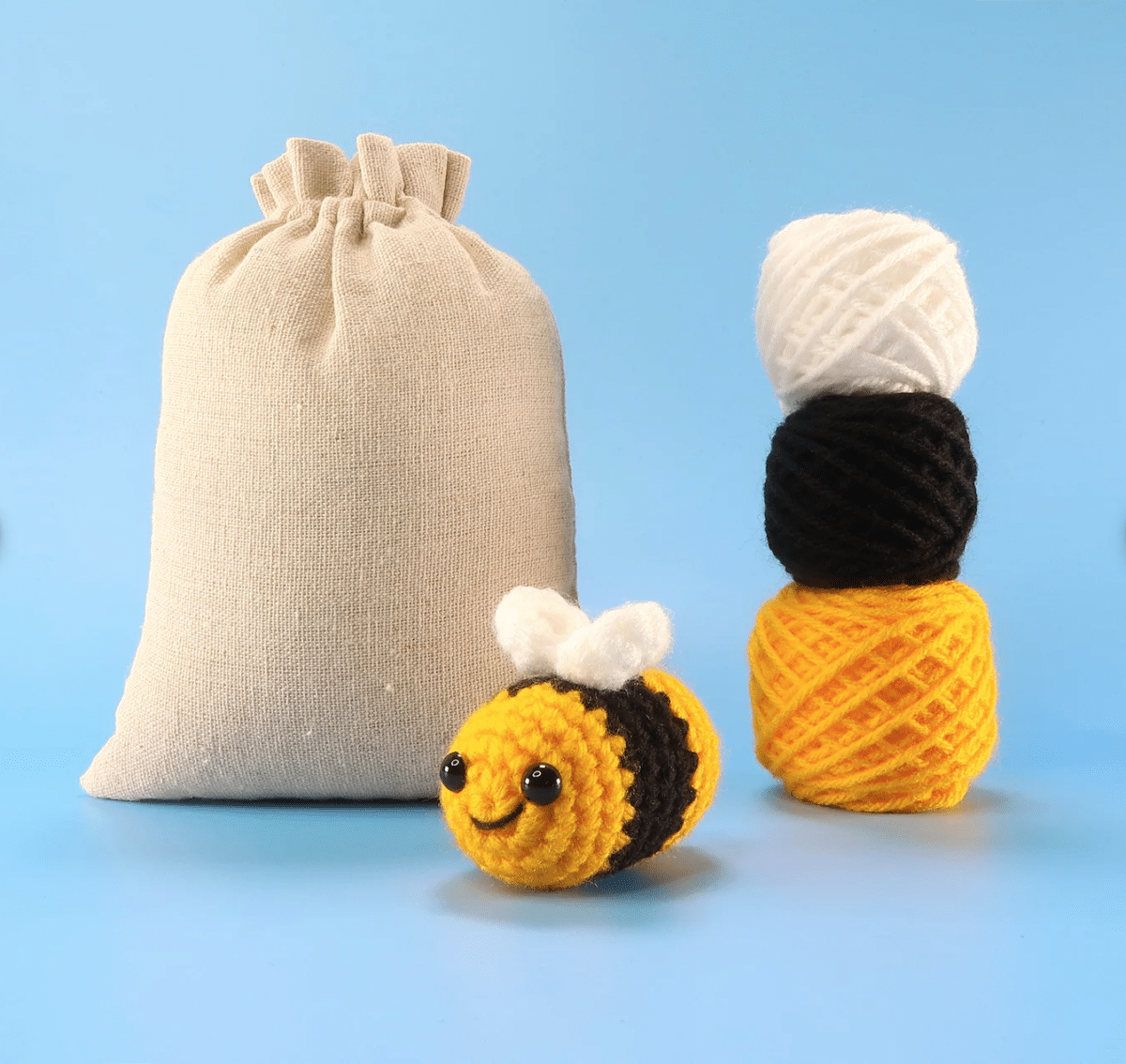 A beginner crochet kit that includes a crocheted bee and a bag of yarn.