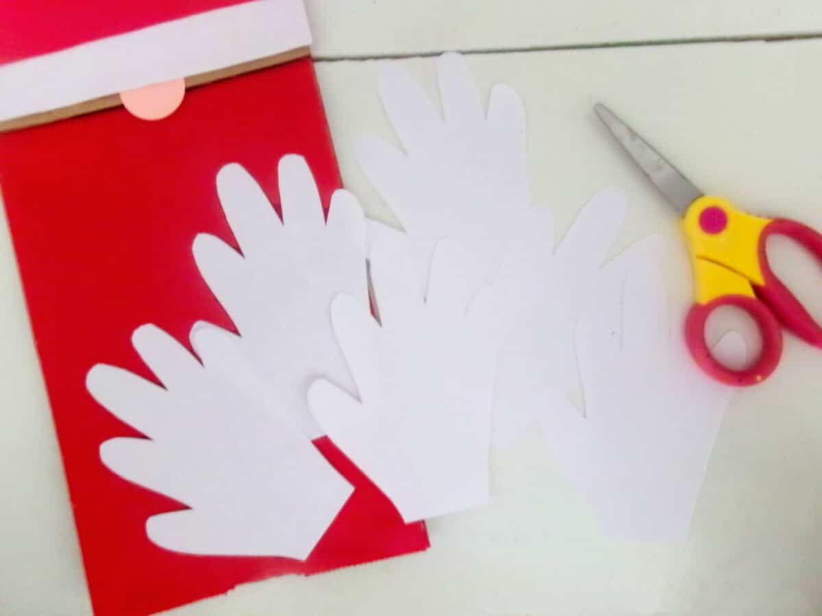 A Santa craft featuring scissors and paper for making a handprint.
