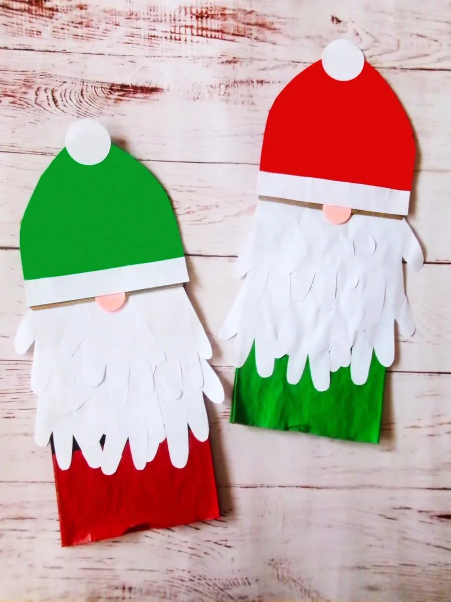 Two Santa Claus paper bags on a wooden table.
