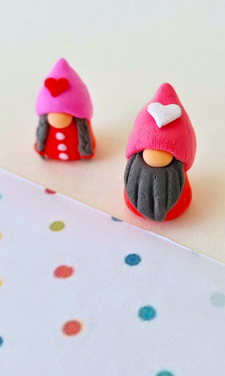 Two little clay gnomes on a piece of paper.