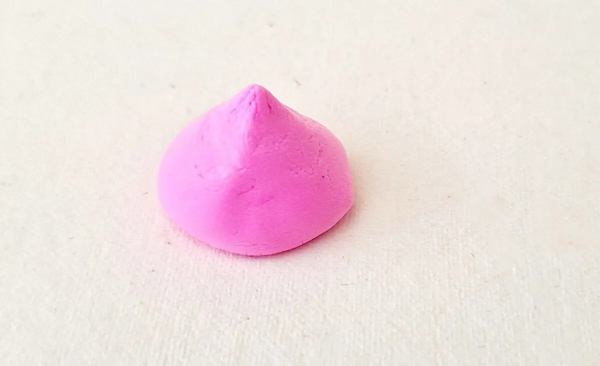Clay Gnome Step 12 A pink object on a white surface.
