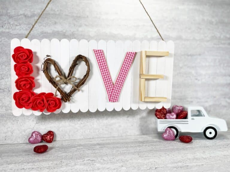A valentine's day sign with roses and a truck.