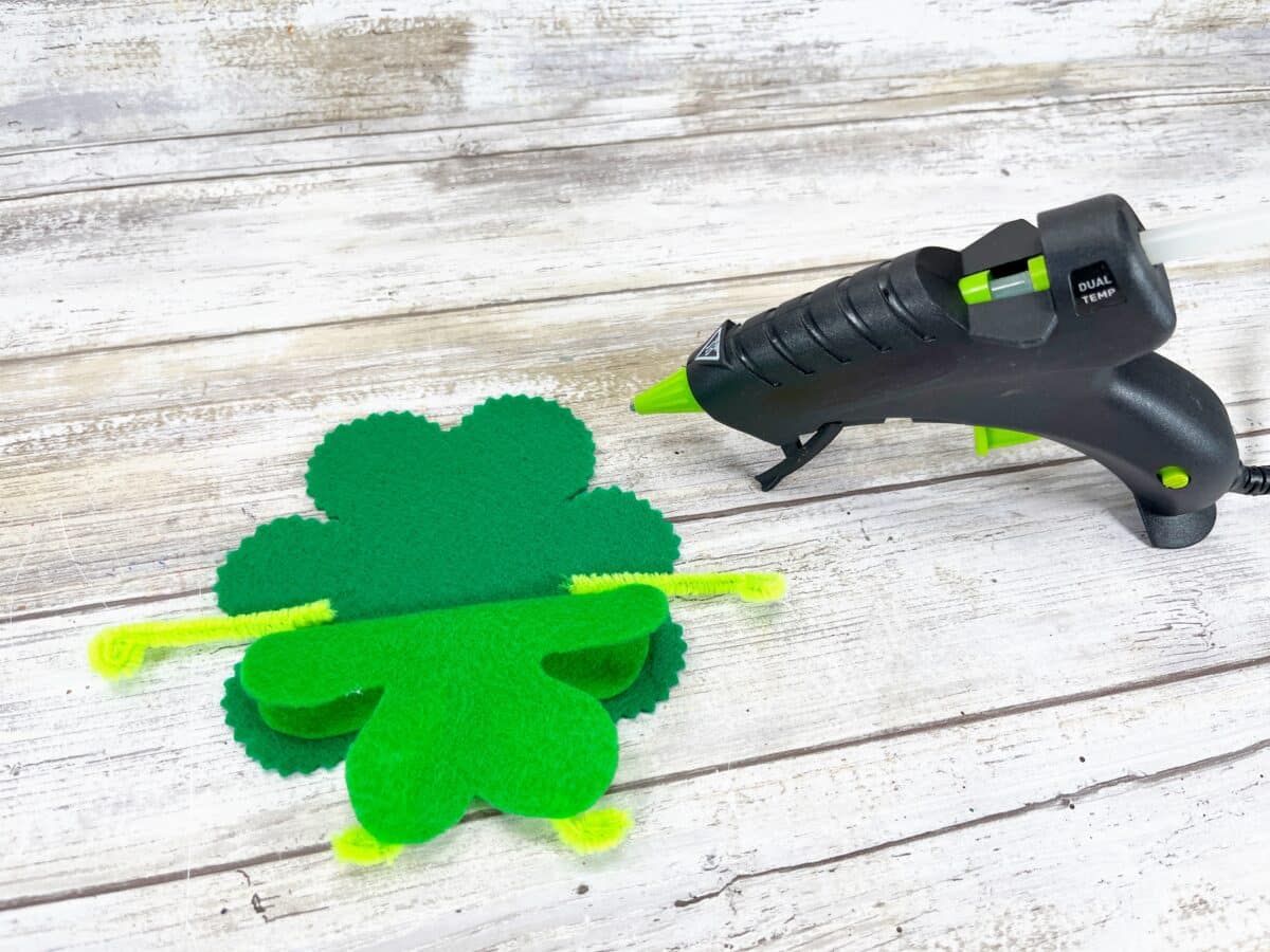 St patrick's day craft with a glue gun and a green shamrock.