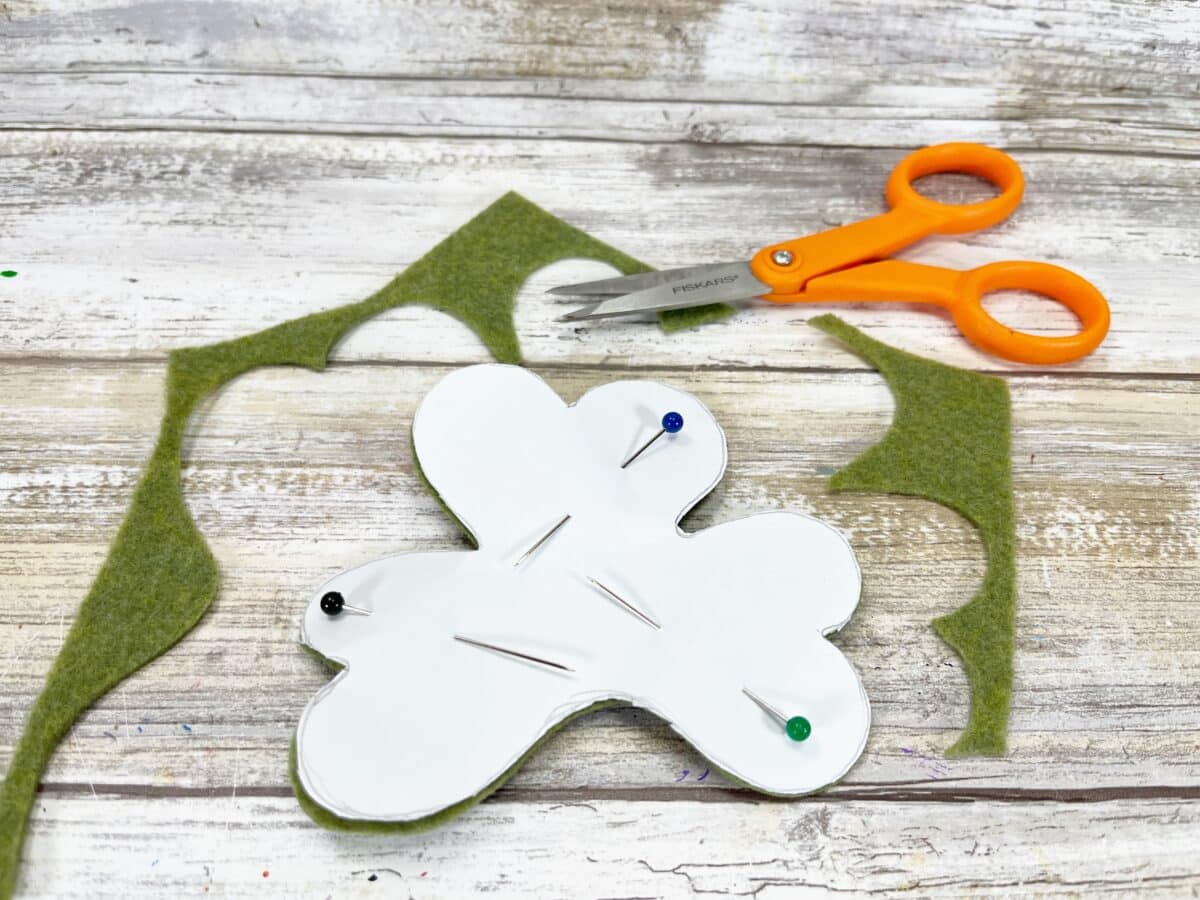 A pair of scissors and a piece of felt on a table.