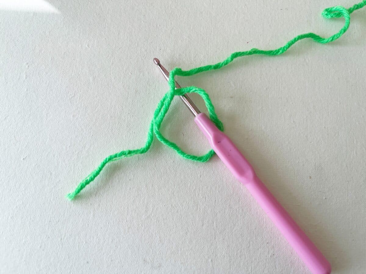 A pink crochet hook and a pink crochet needle.