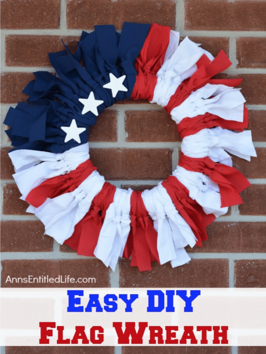 A handmade wreath in red, white, and blue with star decorations, representing the american flag, displayed on a brick wall, with text overlay "easy diy flag wreath.