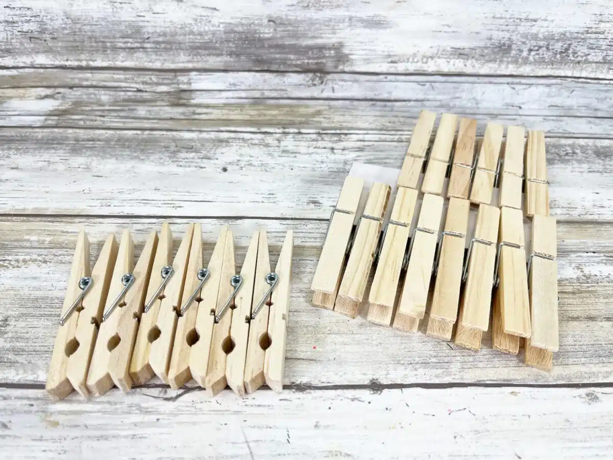 Patriotic Clothespin Stars Step 1 Wooden clothespins arranged on a rustic wooden background.