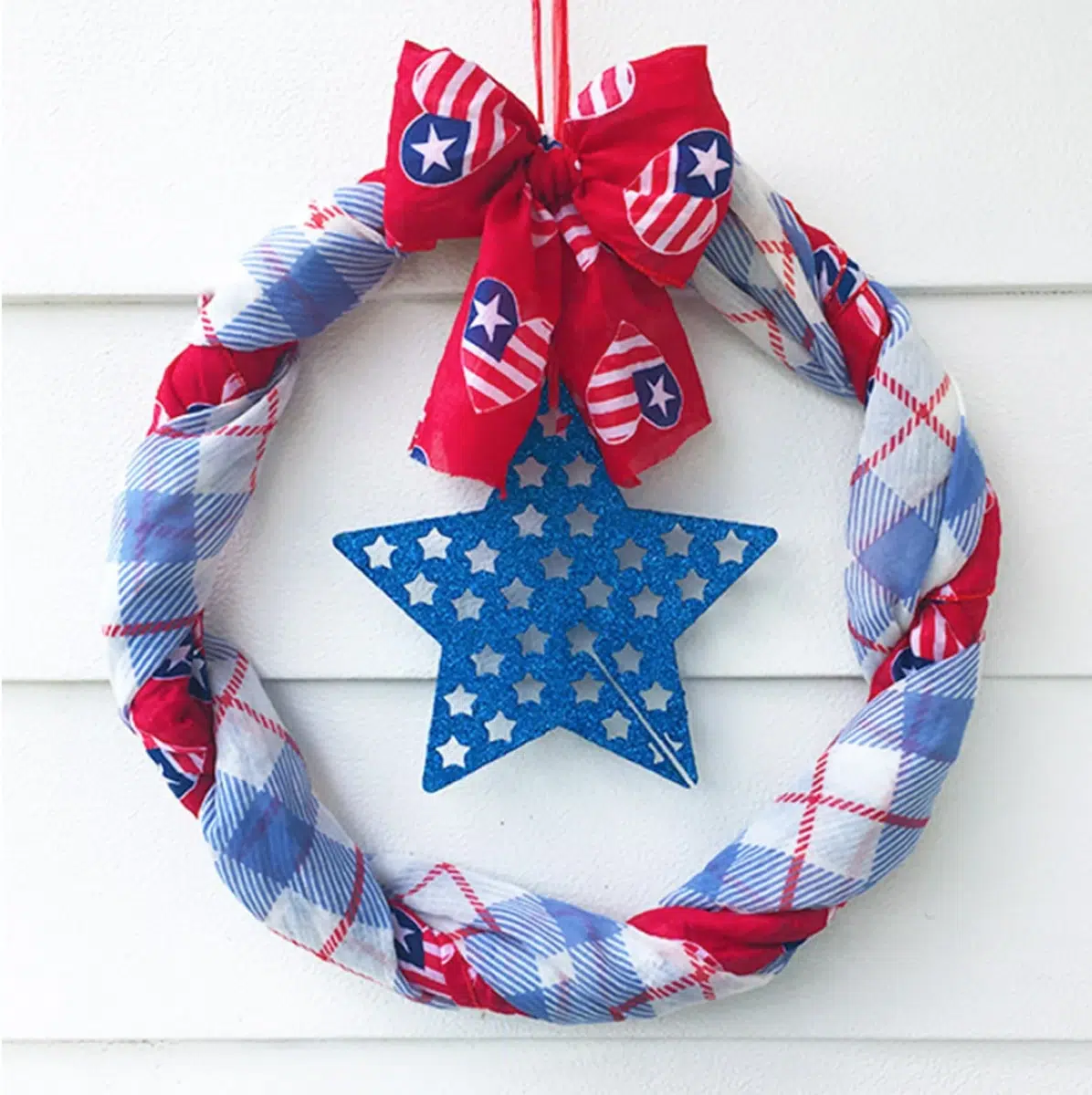 Patriotic Fourth of July wreaths featuring red, white, and blue fabrics with a star centerpiece and bow, likely for American holiday decoration.