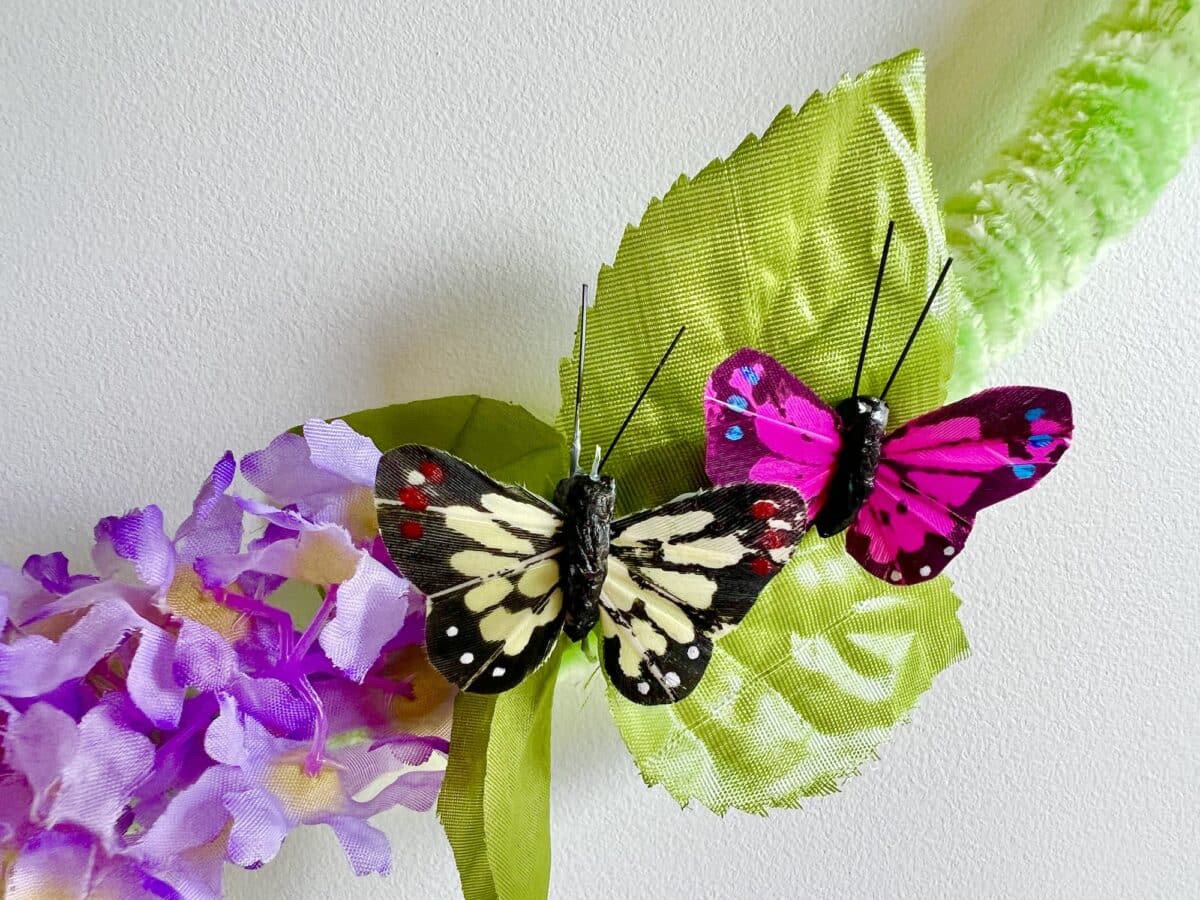 Artificial butterflies and silk flowers on a wall as decorative elements.