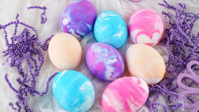 Colorful Cool Whip marbled Easter eggs nestled in shredded paper filler.