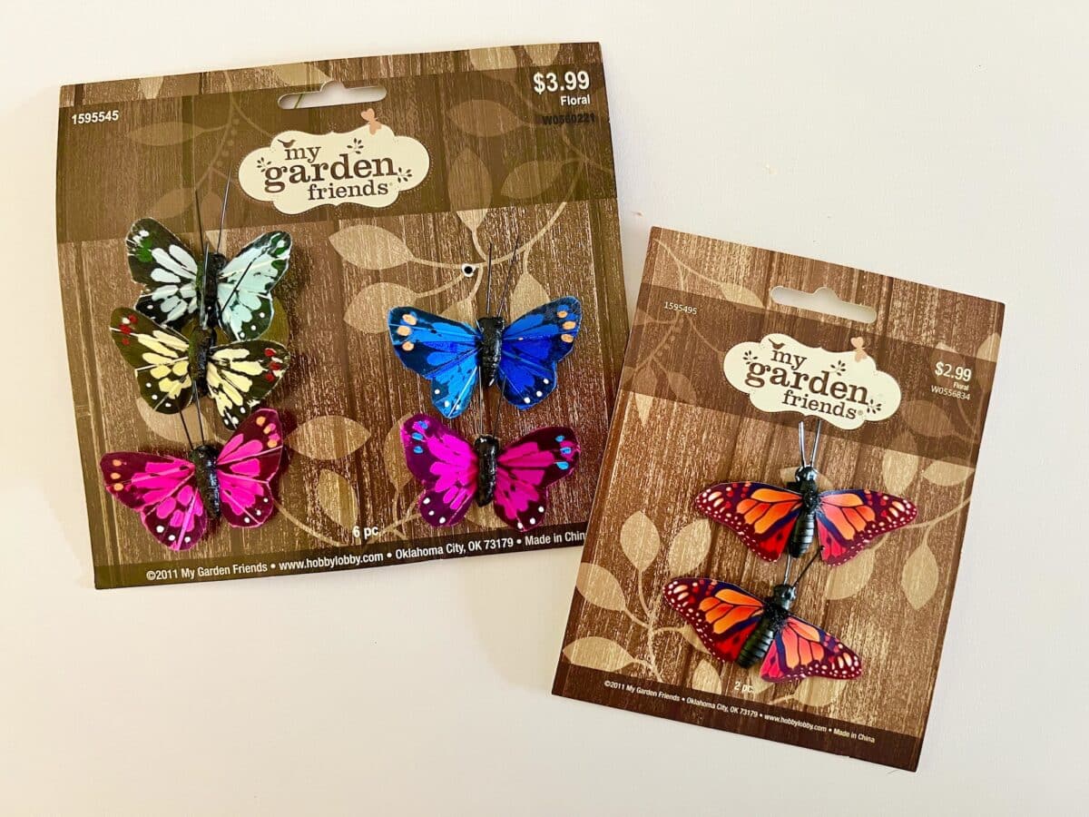 Two packages of decorative butterfly garden stakes with prices displayed.