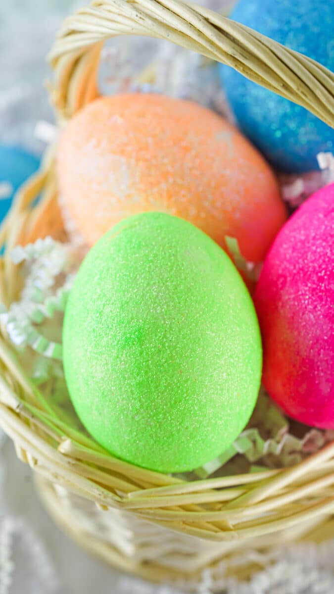 Colorful, DIY glitter Easter eggs in a basket.